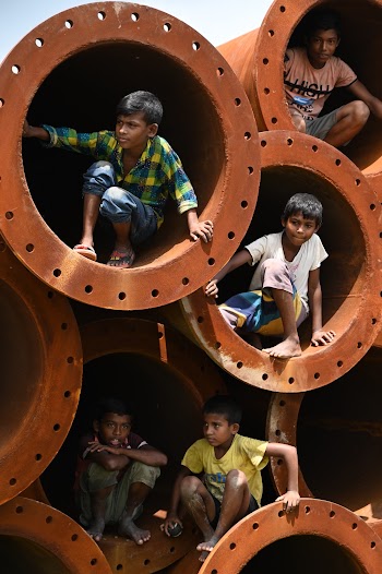 Boys Sitting in Piled Culvert