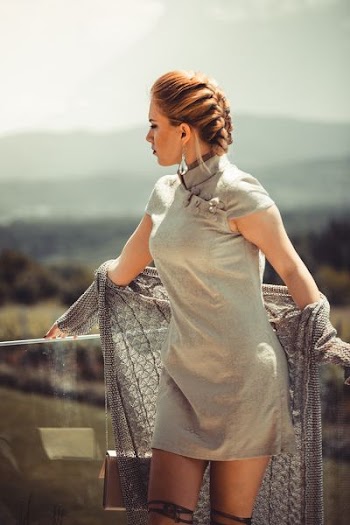 braided hair woman taking photo in corner of glass railings at daytime