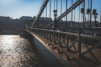 Brass Bridge Near High Rise Building Under Blue Sky