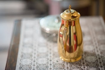 Brass-colored Pitcher on White Textile