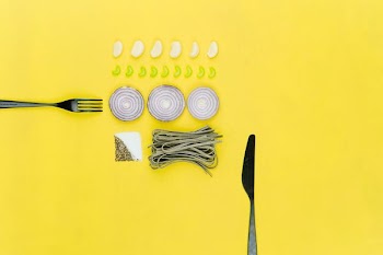 bread knife and sliced onion on yellow table