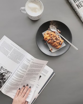 Bread on Round Black Plate Near White Ceramic Cup