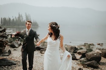 bride and groom standing near body of water