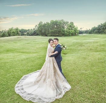 Bride and Groom Standing on Green Grass Field