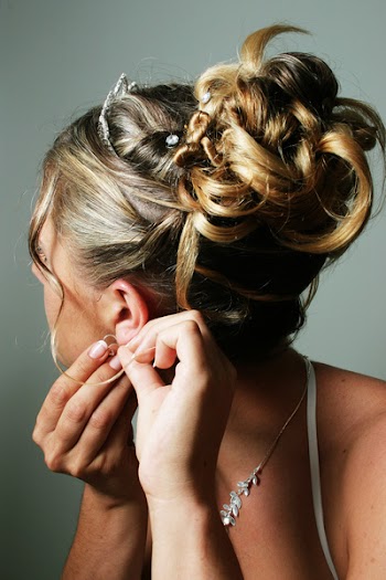 bride on wedding day putting in an earing