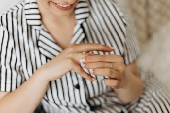 Bride sitting on chair at wedding, focus on wedding ring