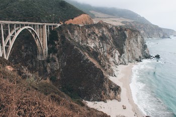 Bridge Across Two Land Formations Near Coast during Foggy Day