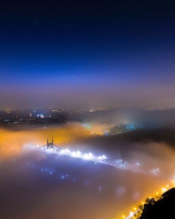 bridge covered with fog during nighttime