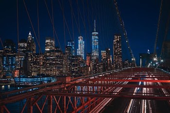 bridge near city buildings during nighttime