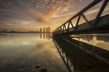 Bridge on Body of Water Near High-rise Building during Golden Hour