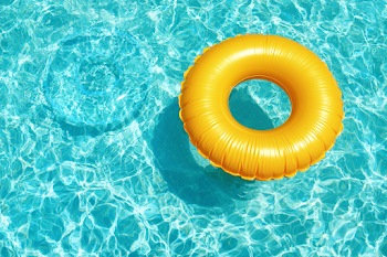 Bright Yellow Inflatable Swim Ring in Turquoise Pool