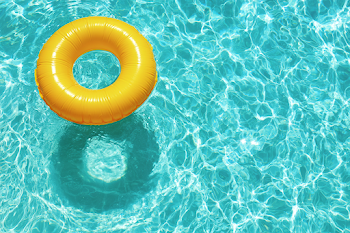 Bright Yellow Inflatable Swim Ring in Turquoise Pool