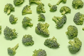 Broccoli Pieces On Green Surface