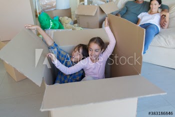 Brother and sister playing inside cardboard box