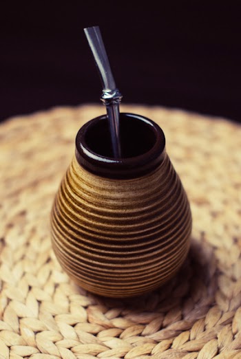 Brown and Beige Ceramic Container With Silver Inside on Brown Braided Textile