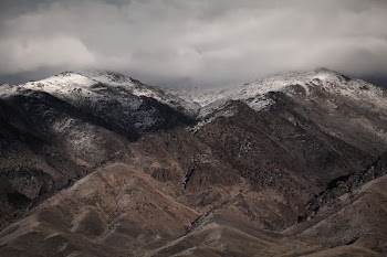 brown and black mountains under cloudy skies
