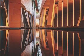 brown and black narrow building with reflection on the water photography