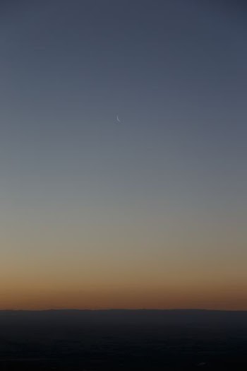 brown and blue horizon with crescent moon