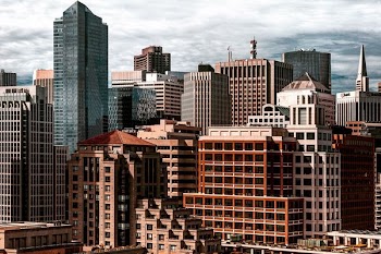 brown and gray concrete buildings taken under white clouds during daytime