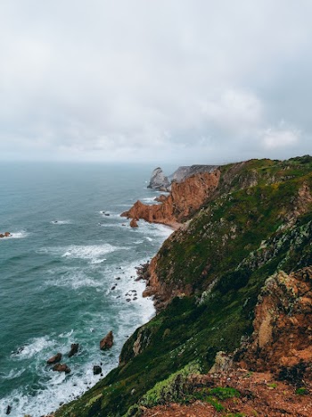 Brown and Green Cliff Beside Body of Water
