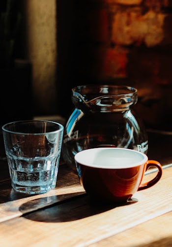 Brown And White Ceramic Cup Besides Clear Drinking Glass