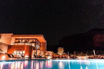 brown and white concrete building beside pool during nighttime