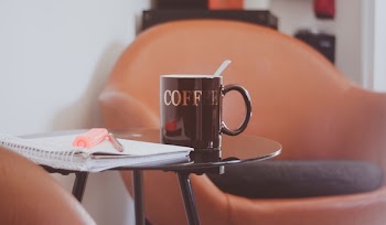 Brown and White Drinking Mug on the Top of Round Glass Top Table