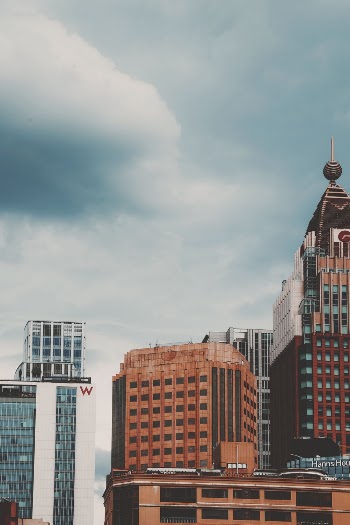 Brown and White High Rise Buildings Under Cloudy Sky