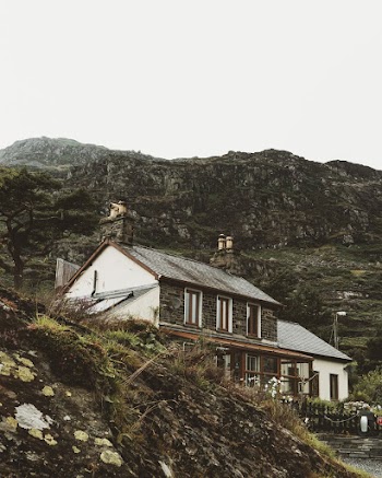 Brown and White House Built On The Foot Of The Mountains