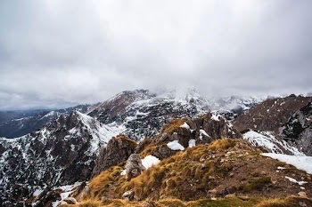 brown and white mountain under cloudy sky