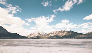 brown and white mountains near sand during daytime