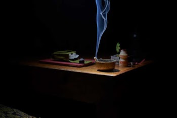 Brown Ashtray With Cigarette Casting Smoke on Table