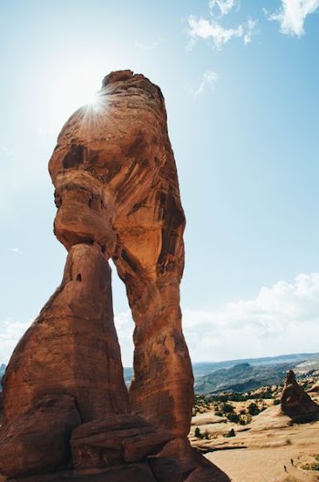 brown boulder near canyon under blue sky