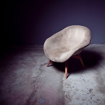 brown bucket chair near wall
