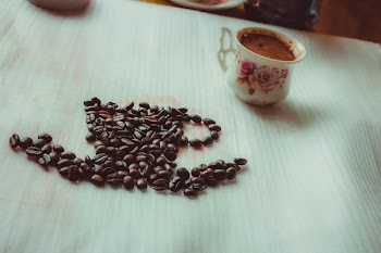 Brown Coffee Beans Beside Ceramic Mug on Table