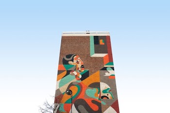 brown concrete building with abstract painting