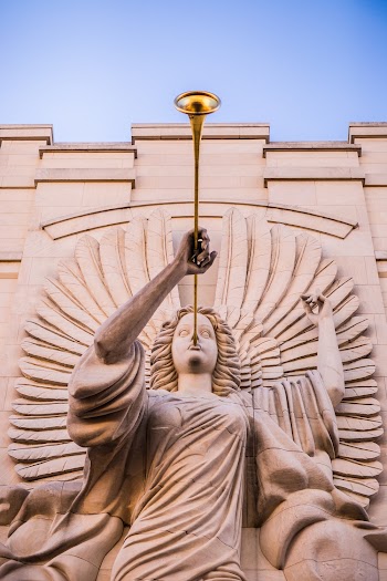 Brown Concrete Statue of Man Holding Trumpet