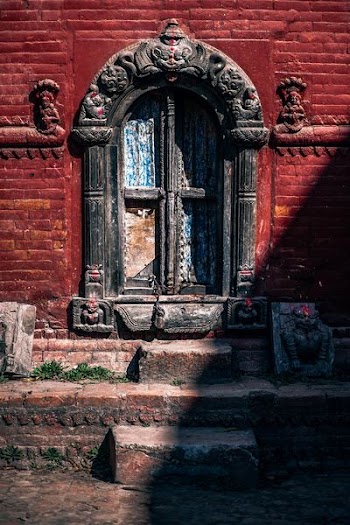 brown concrete structure with blue and gray wooden door