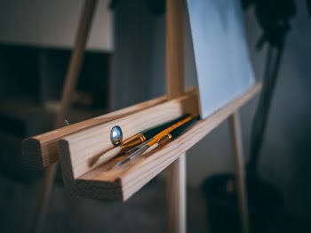 Brown Easel With Pens and Brushes