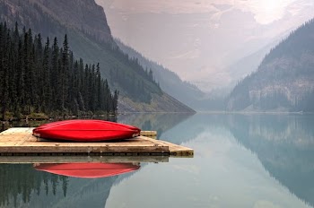 brown floater with red canoe in body of water