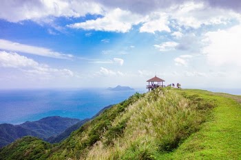 brown gazebo on top of green mountain overlooking sea during daytime landscape photography