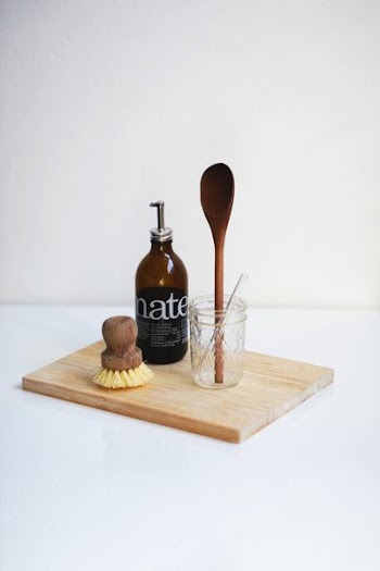 brown glass bottle beside clear glass jar on chopping board