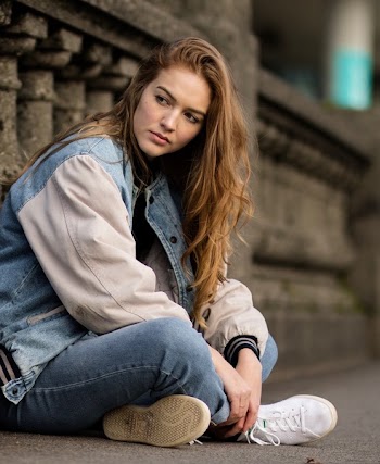 Brown Haired Woman Sitting Beside Gray Concrete Railings