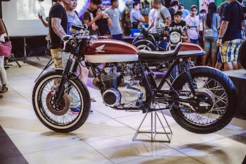 Brown Honda Motorcycle Displayed Inside Building With People