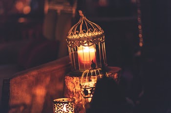 Brown Metal Cage With Lighted Candle