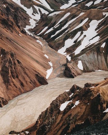 brown mountain covered by melting snow