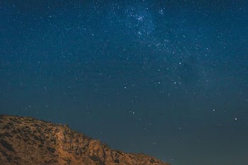 brown mountain under blue and gray sky with stars