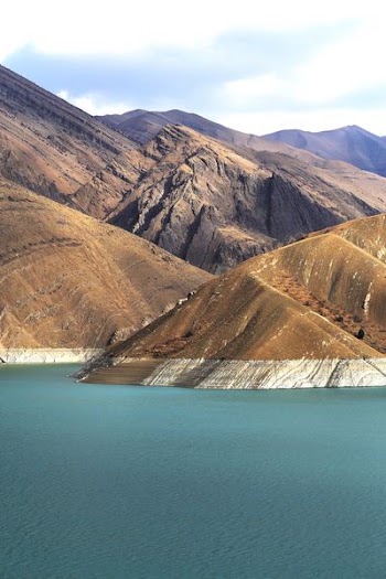 brown mountains near body of water
