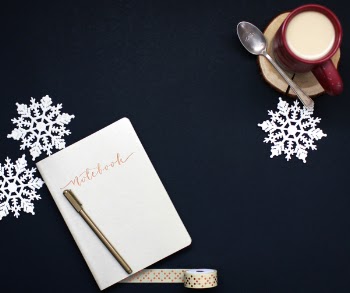 Brown Pen on White Notebook Near Red Coffee Mug and Silver Spoon on Top of Blue Surface