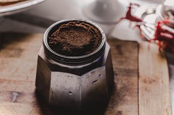 brown powder in gray container on brown surface